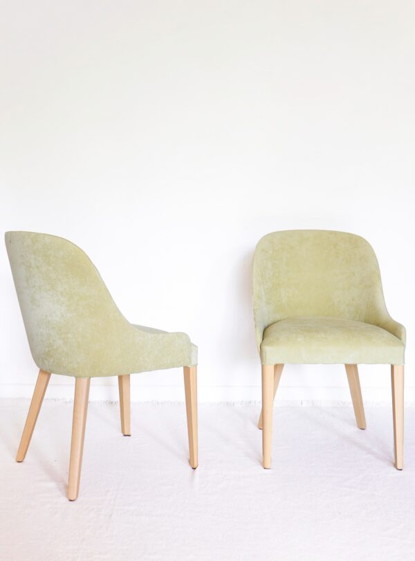 Silla Lisboa de guatambú, tapizada en tono verde claro con respaldo curvo y patas rectas de madera clara; diseño contemporáneo.