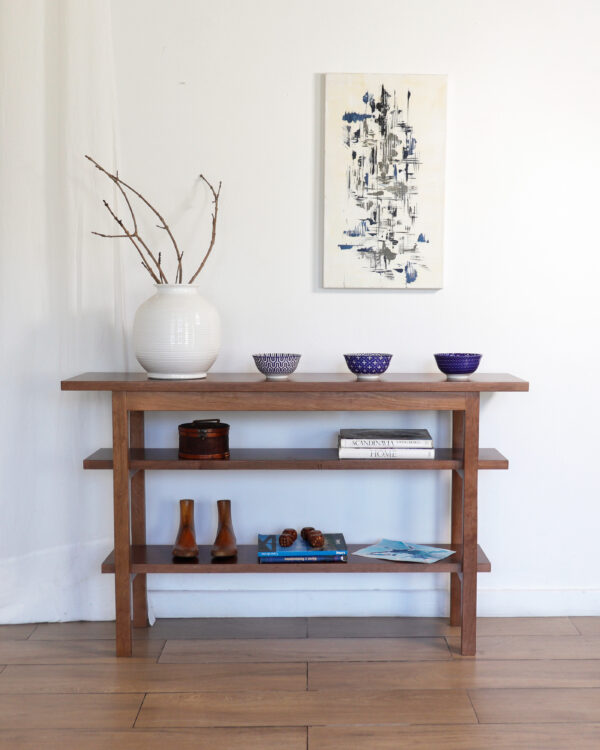 Consola Máximo de madera lenga estilo minimalista con estantes, acompañada de vajilla artesanal y decoración moderna.