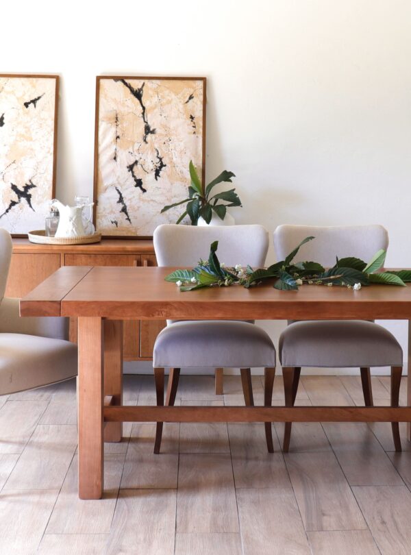 Oporto de guatambú tapizada en tono claro, vista en comedor junto a mesa de madera, estilo elegante y contemporáneo.