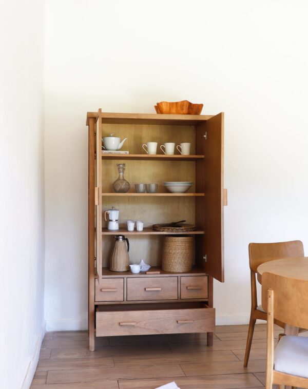 Aparador Berna alto de madera kiri y rafia con puertas abiertas mostrando vajilla, diseño nórdico funcional para hogar.