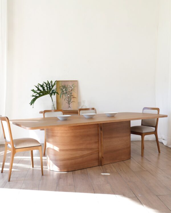 Mesa Lanín de comedor en madera kiri estilo contemporáneo con diseño rectangular, acompañada por cuatro sillas y platos decorativos