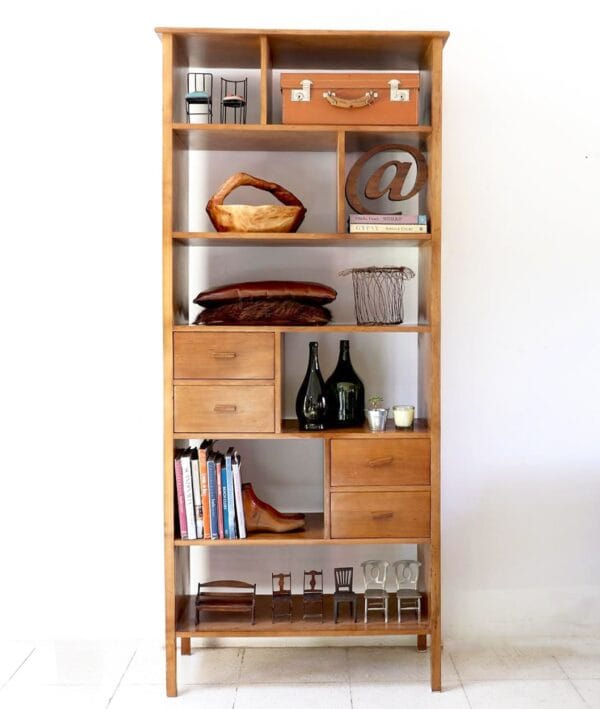 Biblioteca Máximo de madera lenga con diseño atemporal, estantes abiertos y cajones funcionales, decorada con objetos y libros en un ambiente moderno.