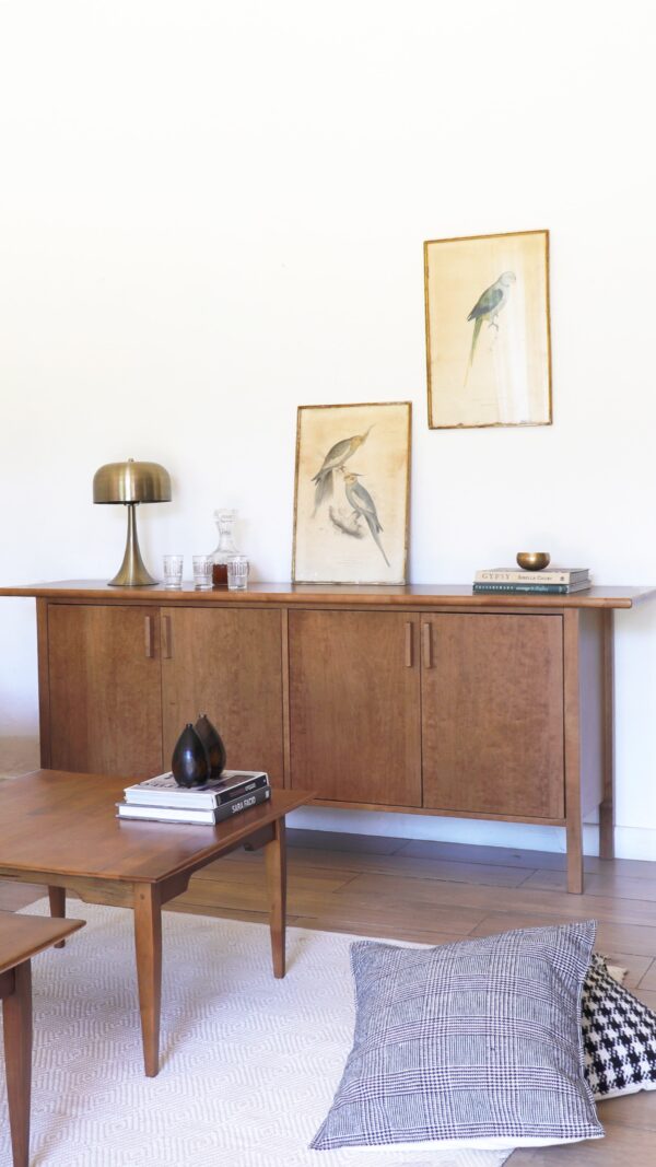 Aparador vajillero Máximo de madera lenga en estilo sobrio, integrado en un living minimalista con sillón beige y mesas auxiliares.
