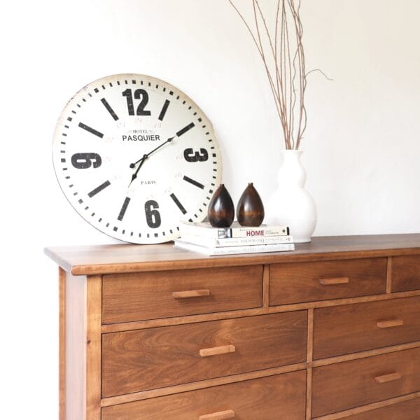 Cómoda Máximo XXL de madera lenga estilo atemporal, detalle superior con reloj decorativo y objetos minimalistas