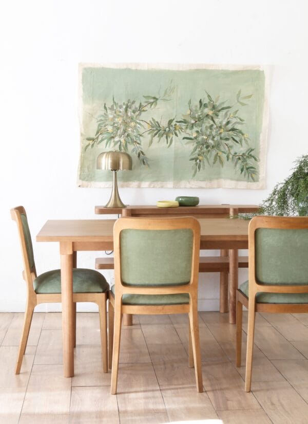 Mesa de comedor Madrid rectangular en madera kiri estilo nórdico con seis sillas verdes y decoración mural en tonos naturales