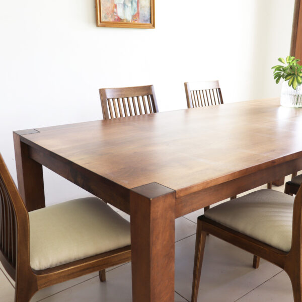 Detalle de la mesa de comedor Estocolmo en madera lenga estilo moderno con sillas de diseño recto y asiento tapizado claro