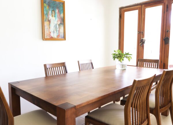 Mesa de comedor Estocolmo moderna en madera lenga rectangular con seis sillas de respaldo alto y centro de mesa con planta verde