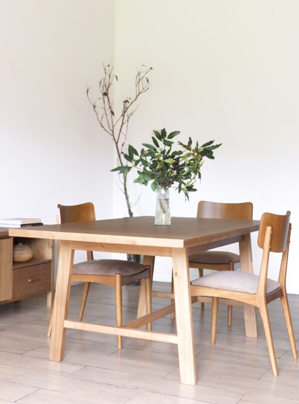 Mesa de comedor Oslo rectangular en madera kiri estilo hygge con cuatro sillas tapizadas y decoración minimalista