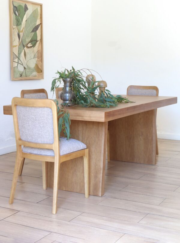 Mesa Serbia estilo japandi en madera kiri con sillas tapizadas color beige y composición decorativa minimalista
