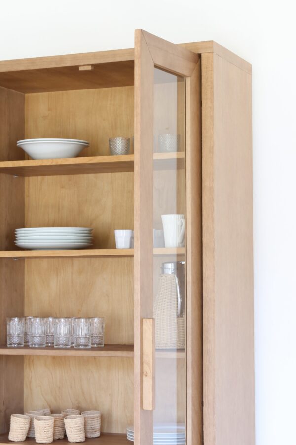 Detalle de la Vitrina Provance en madera kiri con puertas de vidrio abiertas y estantes organizados.