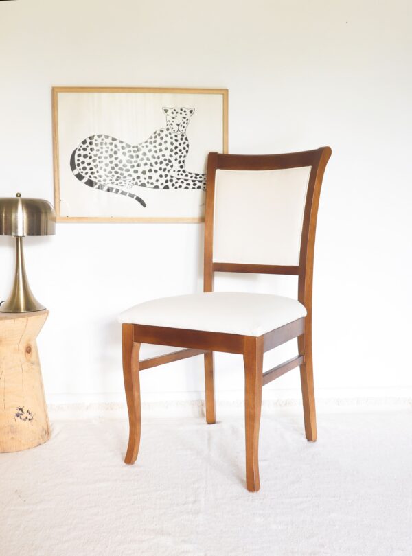 Silla Madrid en madera guatambú vista lateral, con respaldo curvo y diseño elegante tapizado en tela clara.