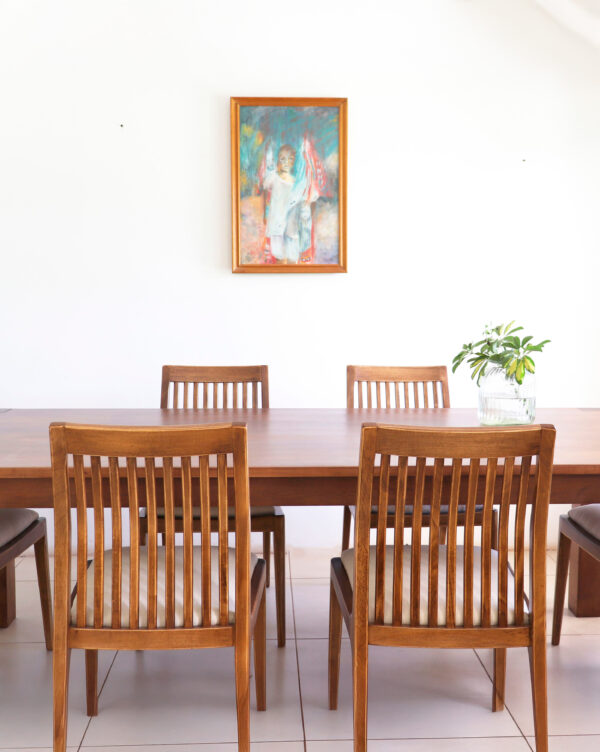 Silla Olsen de madera guatambú con respaldo de varillas verticales y asiento tapizado en tono beige, estilo atemporal.