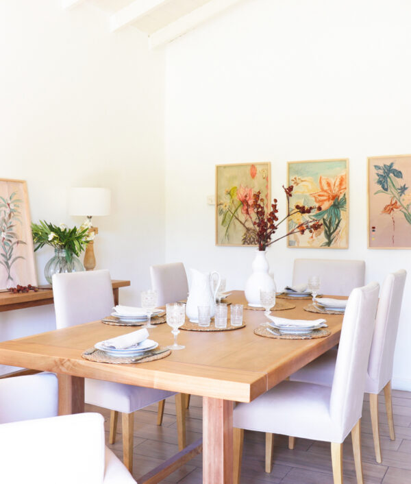 Conjunto de comedor con sillas vestidas de guatambú tapizadas en tela beige, estilo elegante, dispuestas alrededor de una mesa de madera.
