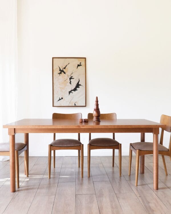 Conjunto de comedor con mesa Madrid en lenga estilo nórdico, acompañado de sillas de respaldo curvo y tapizado en beige claro.